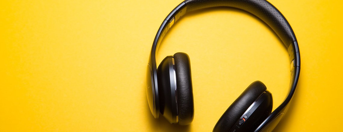 Headphones on yellow background. Photo by Malte Wingen on Unsplash