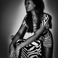 woman wearing a zebra print dress behind a zebra print chair.