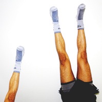 2 sets of the same legs doing a handstand in front of a white wall.