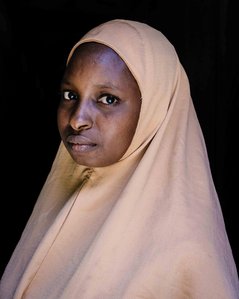KADUNA, NGA - August 9, 2023: Portrait of Shafa’atu Nuhu, a 22 year old lady in her home at  Kabaya community, Soba LGA, Kaduna state, Nigeria.  Shafa’atu Nuhu bears responsibilities of a wife, a mother and a senior secondary school student two student. S