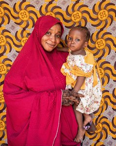 SOKOTO, NGA - July 3, 2023: Portrait of Hafsat Abubakar and her mum; Sadiya Abubakar in their home at Gidan Igwai, Sokoto North LGA, Nigeria. Hafsat is a 9month old baby, she started her nutrition treatment when she was 7 months old. With visible physical