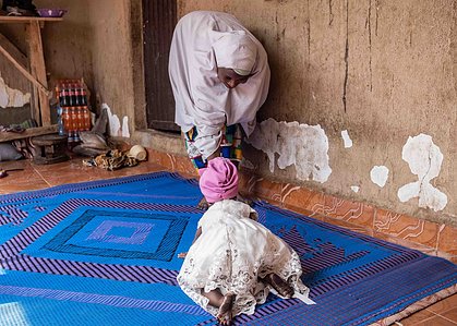 SOKOTO, NGA - July 3, 2023: Nana Firdausi Umar crawls to her mum in their home at Jiddawa community of Rumbukawa, Sokoto North LGA, Nigeria. Nana Firdausi is a 10 month old baby, she started her nutrition treatment when she was 8 months old. With visible 