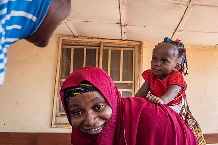 SOKOTO, NGA - July 6, 2023: Sadiya Abubakar backs Hafsat happily as Hafsat was discharged from the Gidan Igwai Primary health center and heads back home at Sokoto North LGA, Nigeria. CREDIT: Taiwo Aina 