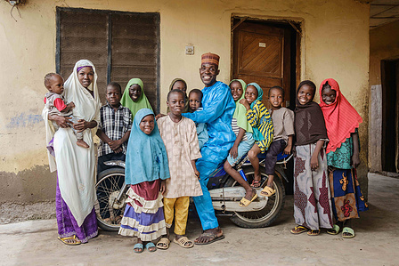YOLA, NGA - October 5, 2023: Portrait of Salihu Yahaya (42); a livestock farmer and his family in front of his house located in Dasin Hausa community, Fufoire LGA, Adamawa State Nigeria. Salihu Yahaya is a beneficiary of climate resilency project. Accordi