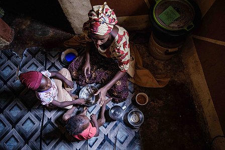 KADUNA, NGA - August 9, 2023: Shafa’atu Nuhu, 22, having lunch with her two daughters (Salma; aged 5 and Nabila aged 1 an a half year old) in her home at Kabaya community, Soba LGA, Nigeria. Shafa’atu had an early marriage, she got married to her husband 