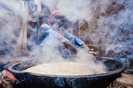 KADUNA, NGA - August 11, 2023: Portrait of Asiya Ja’afar  frying fish in front of her house at Anguwan Malamai, Zaria, Kaduna State, Nigeria. Asiya also hawks fried fish sourced by her father for sale whenever she is not at the poultry house. CREDIT: Taiw