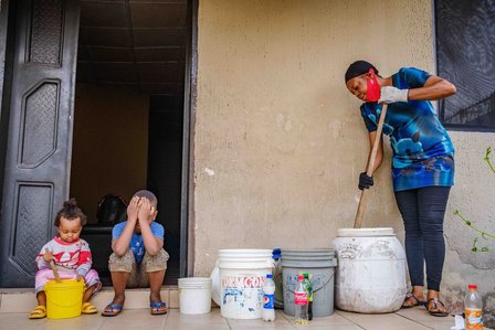 RIVERS, NG - January 28, 2023: Precious with children as she mixes chemical used in production of her home made soap on January 28, 2023 in Port Harcourt, Rivers state, Nigeria. Precious Jessica; a serial entrepreneur, she is also a farmer twice&#x2F;thrice a 