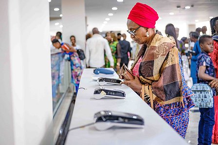 LAGOS, NGA - FEBRUARY 12, 2023: Church member pays her offering using displayed Point-Of-Service payment units on February 12, 2023 in Global Citadel Community Church, Lagos, Nigeria. Churches now receive tithes and offerings digitally, there is no much c