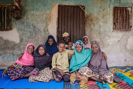 YOLA, NGA - October 3, 2023: Portrait of Shaibu Mohammed (51); a farmer and his family in front of his house located in Dasin Hausa community, Fufoire LGA, Adamawa State Nigeria. Shaibu Mohammed is a beneficiary of Google climate resilency project. After 