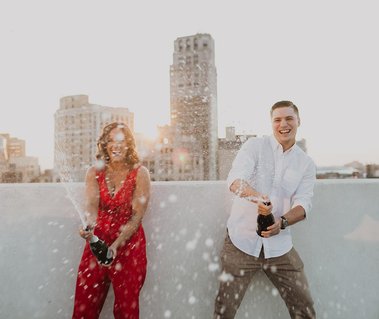 engaged couple popping champagne in the city of Detroit