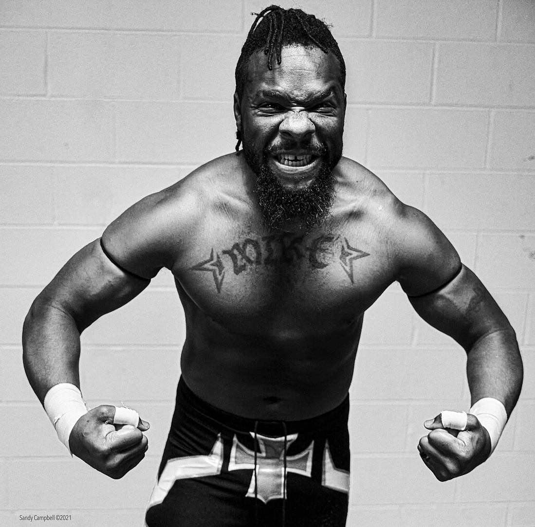 Wrestler "Mike" flexes his muscles in the pre-match warm-up.
