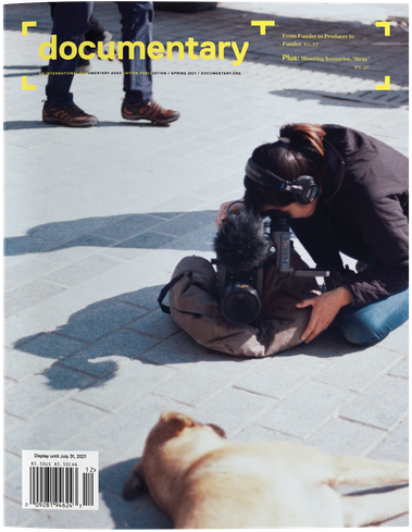 Cover of Spring 2022 issue of Documentary magazine with Elizabeth Lo on the ground shooting a stray dog.