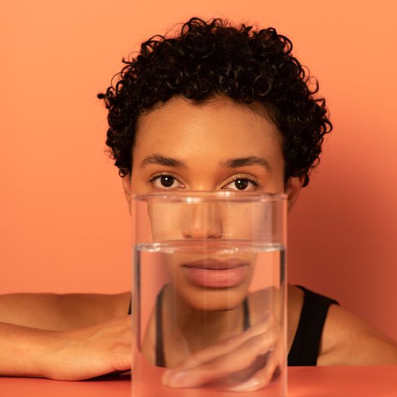 an experimental beauty photography of a BIPOC model on a peach background
