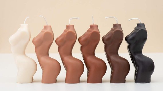6 Female body candles arranged from light to dark on a clean commercial beige photography background