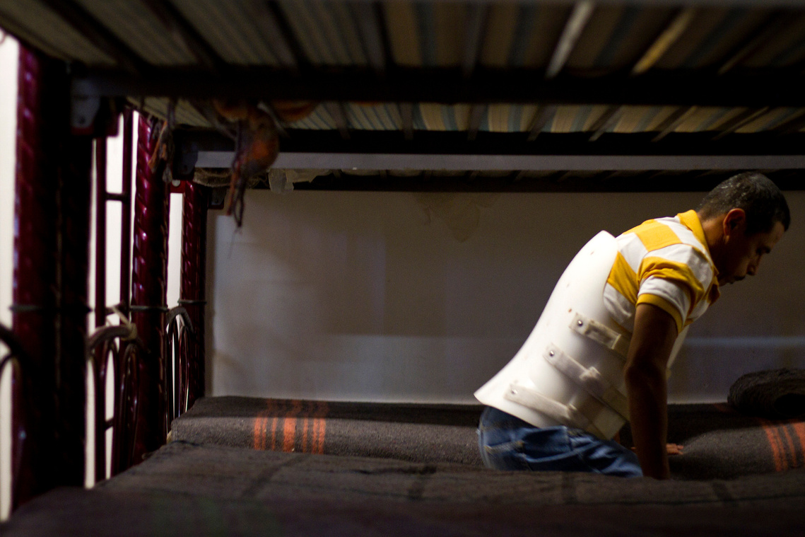 Rodriguez braces himself as he gets up from his bunk bed at Albergue San Juan Bosco after a brief nap. 