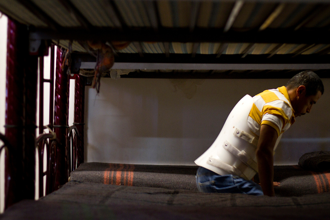 Rodriguez braces himself as he gets up from his bunk bed at Albergue San Juan Bosco after a brief nap. 
