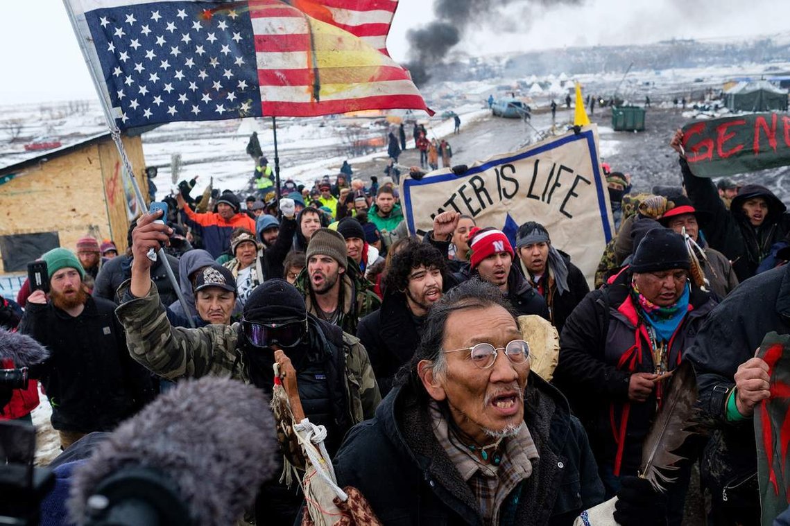 Nathan Phillips and other water protectors exit Oceti Sakowin Wednesday afternoon in a peaceful prayer march held for those choosing to leave the campground ahead of the deadline imposed by the Army Corps of Engineers.