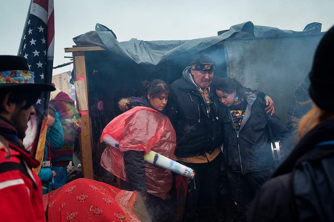 Raymond Kingfisher hugs loved ones as he gives a heartfelt speech thanking campers for their support and prayers at the Oceti Sakowin campground. 