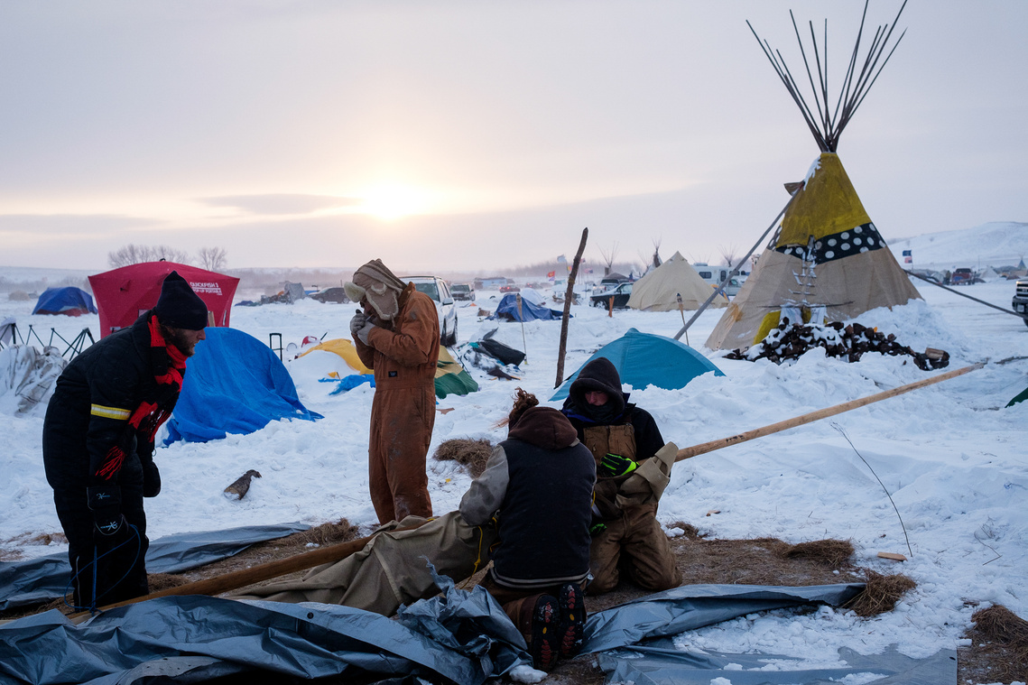 A group of Dakota Access Pipeline protesters dismantle their tipi before packing up to leave the Oceti Sakowin campground on Wednesday, Dec. 7, 2016.