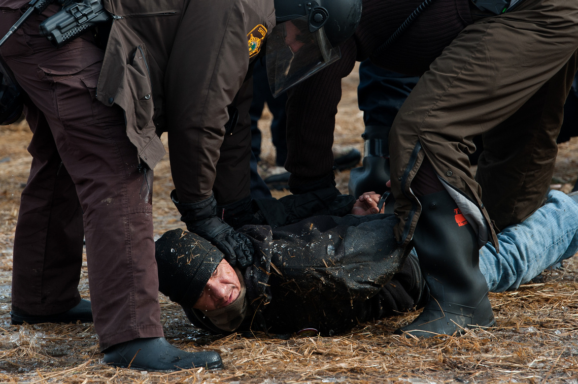 A Dakota Access Pipeline protester is arrested Morton County Sheriff's Department officers as North Dakota law enforcement begin to raid the Oceti Sakowin campground on Feb. 23, the day after the deadline to clear the camp near Cannon Ball, N.D.