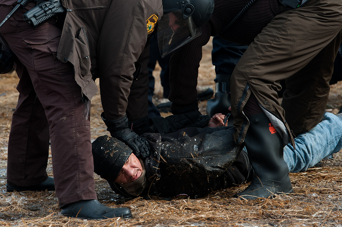A Dakota Access Pipeline protester is arrested Morton County Sheriff's Department officers as North Dakota law enforcement begin to raid the Oceti Sakowin campground on Feb. 23, the day after the deadline to clear the camp near Cannon Ball, N.D.