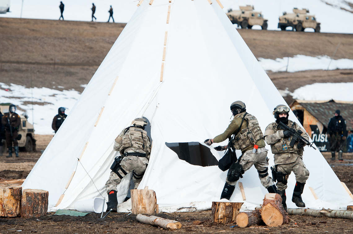 North Dakota law enforcement officers slash and enter a tarpee during a raid on the Oceti Sakowin campground on Feb. 23 north of Cannon Ball, N.D.