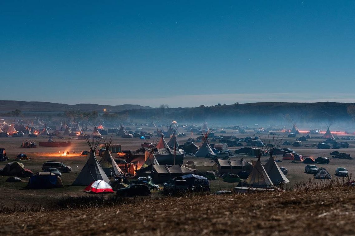 A thick veil of campfire smoke hangs over tipis and tents Friday, Aug. 14 at the Oceti Sakowin campground.