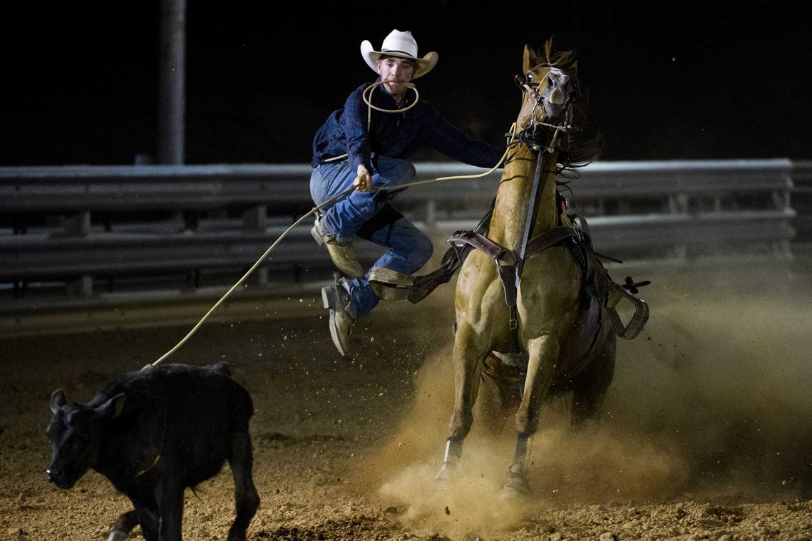 Reign Dobbins leaps off his horse as he attempts to rope a calf at J Rest Farm Thursday, April 22, 2021.
