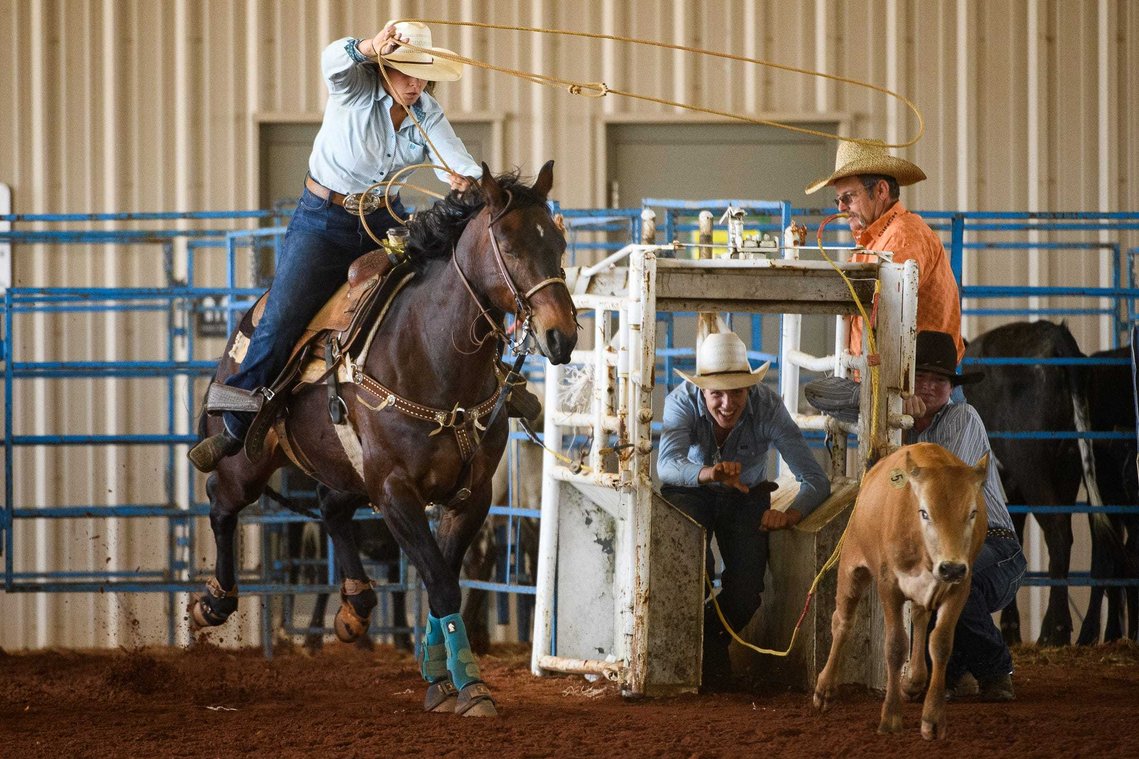 Sally Poteat takes off form the chute while competing in the roping event during a rodeo at the Crescent High School FFA Arena Saturday, May 1, 2021.