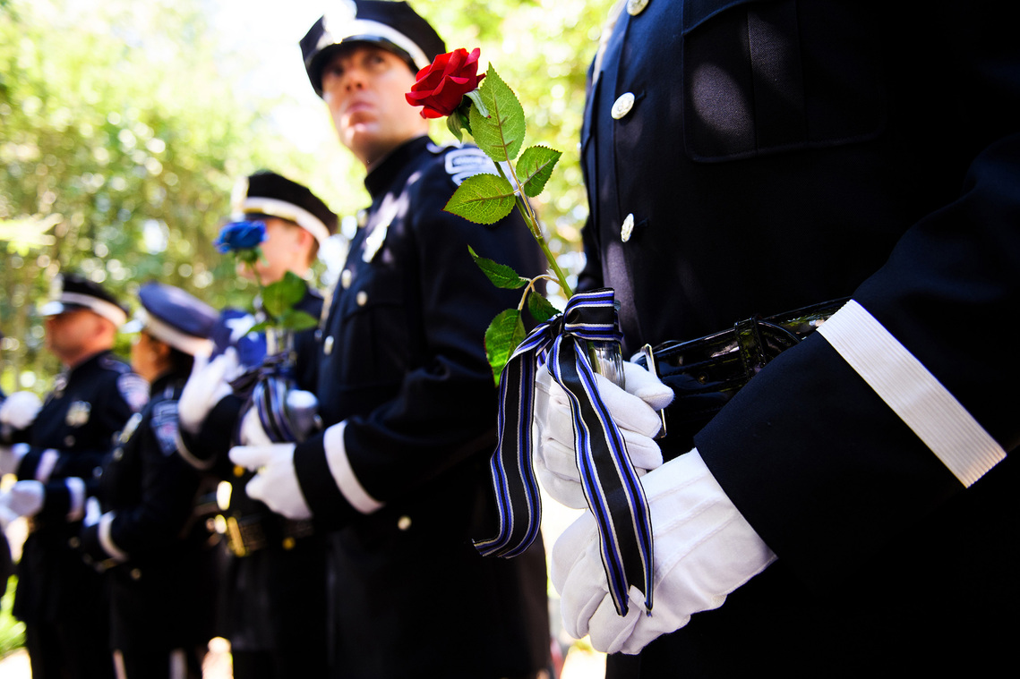 Greenville Police honor guard member Andrew Hamilton holds a vase containing a rose during memorial service honoring fallen Greenville County law enforcement officers at the Law Enforcement Center Tuesday, May 21, 2019.