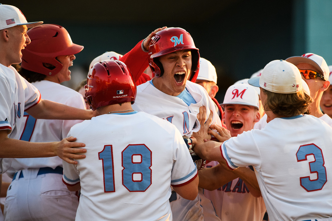 J.L. Mann's Caleb Freeman (22) celebrates with his teammates after scoring a run during their playoffs game Tuesday, April 23, 2019.