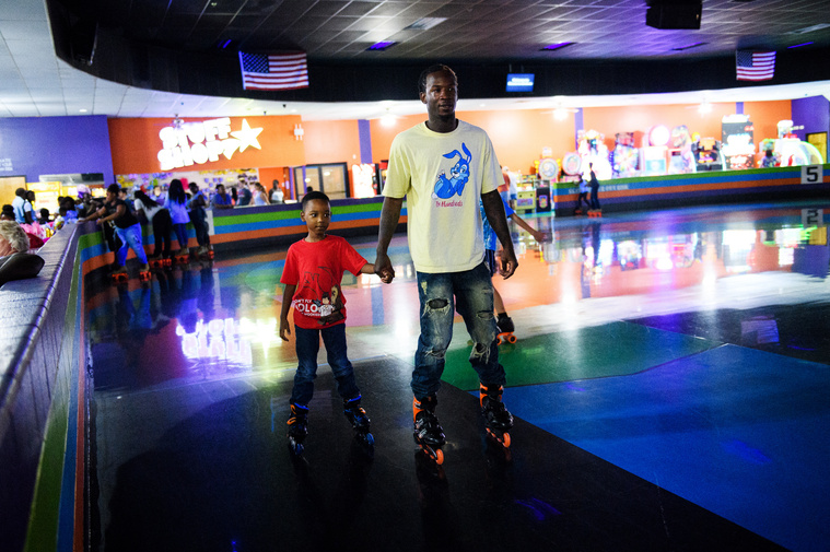 Isaih Kinloch rollerblades with his son Robbie Johnson, 7, during his birthday party at Music In Motion Family Fun Center on Saturday, July 28, 2018.