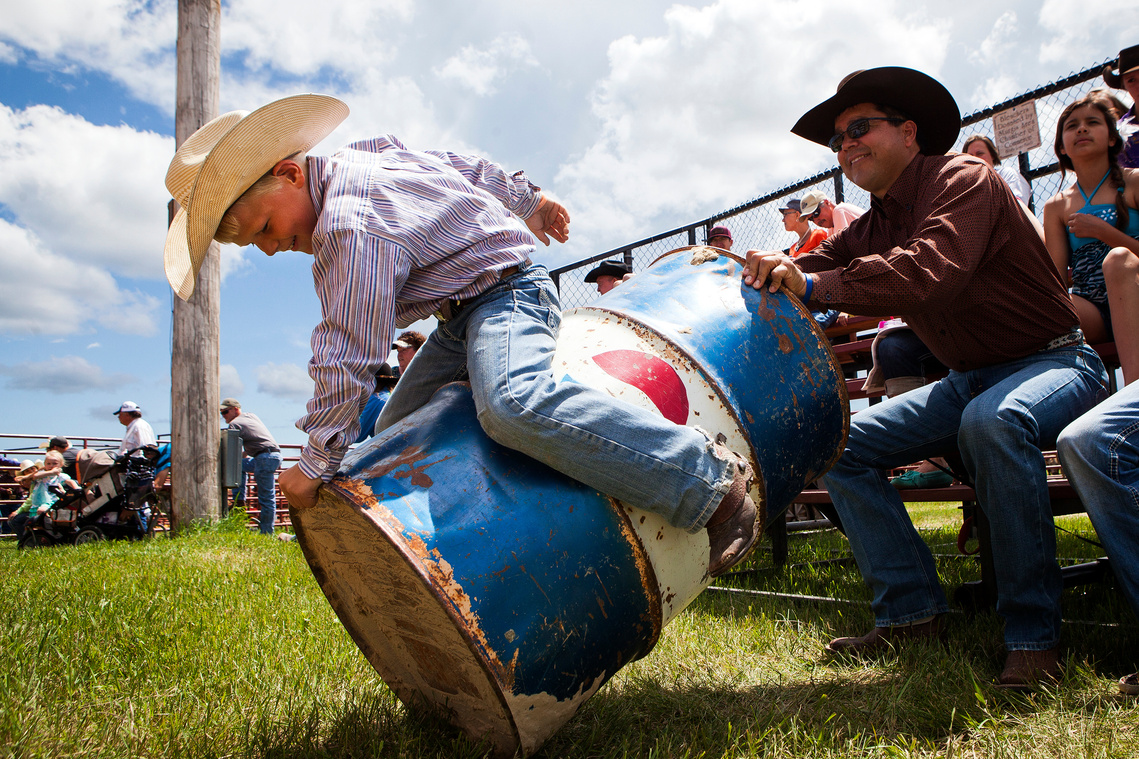 Rylan Elshere, 8, holds onto a trash can as his uncle, Bill Eastman, lifts it off the ground while the two enjoy the afternoon with family at the Sturgis Regional Rodeo on Saturday, June 13, 2015.