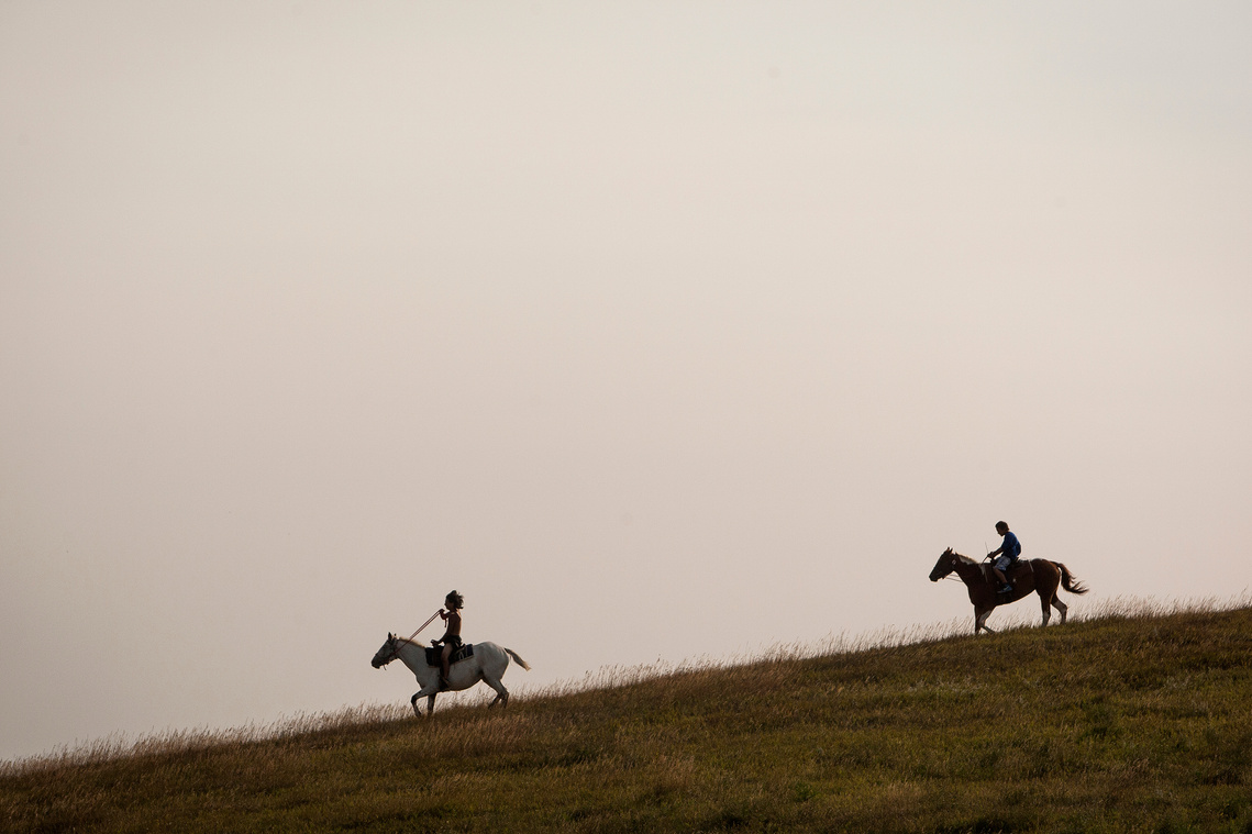 Two boys ride horses down a hill Thursday, Sept. 1 at the Oceti Sakowin campsite north of Cannonball, N.D.