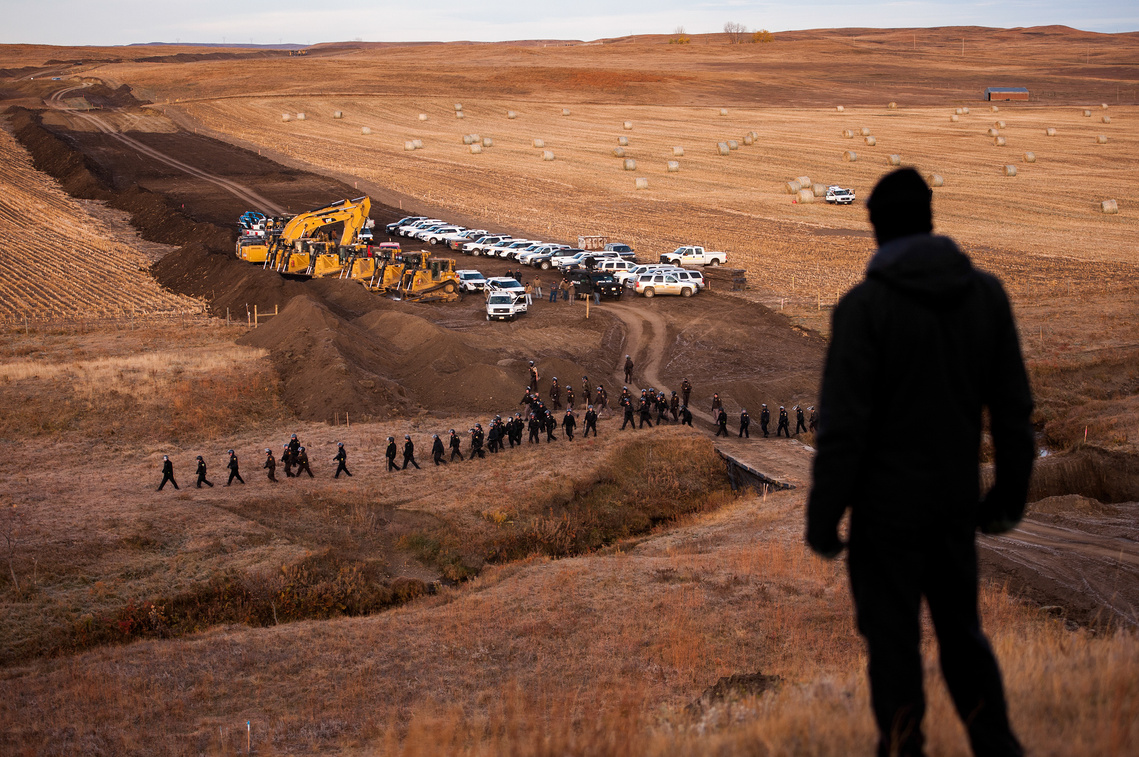 A man watches as North and South Dakota law enforcement officers move to block the advancement of a demonstration at a Dakota Access pipeline construction site Saturday, Oct. 22 northwest of Cannon Ball, N.D.