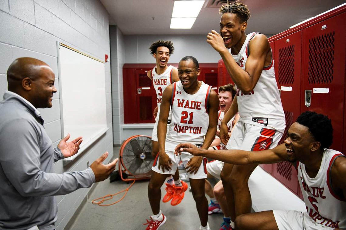 Wade Hampton players celebrate with head coach Reggie Choplin after their game against Woodmont Wednesday, Feb. 19, 2020.