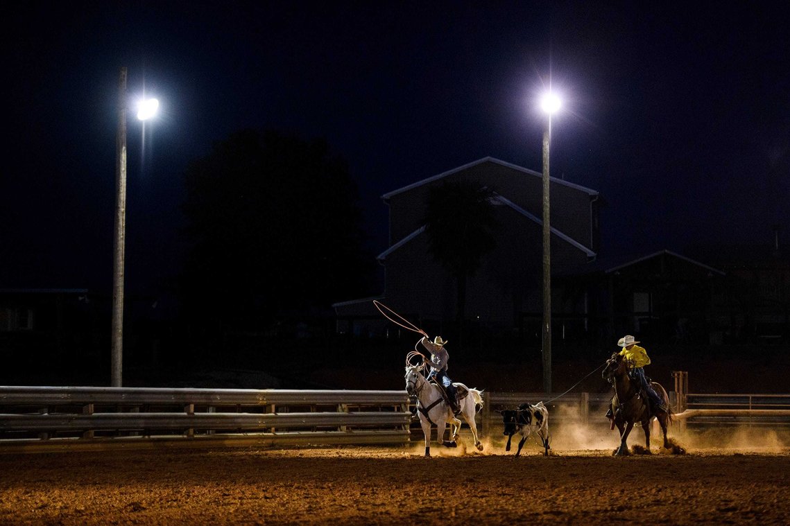 Colton Schlock and Reign Dobbins chase after a calf as they practice team roping at J Rest Farm Thursday April 15, 2021.