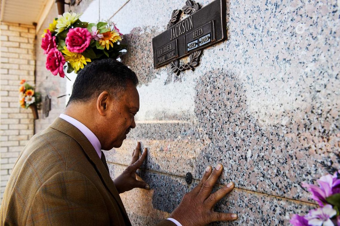 The Rev. Jesse Jackson places his hands over the grave of his mother Helen Burns Jackson and prays at Resthaven Memorial Gardens on Friday, Jan. 19, 2018.