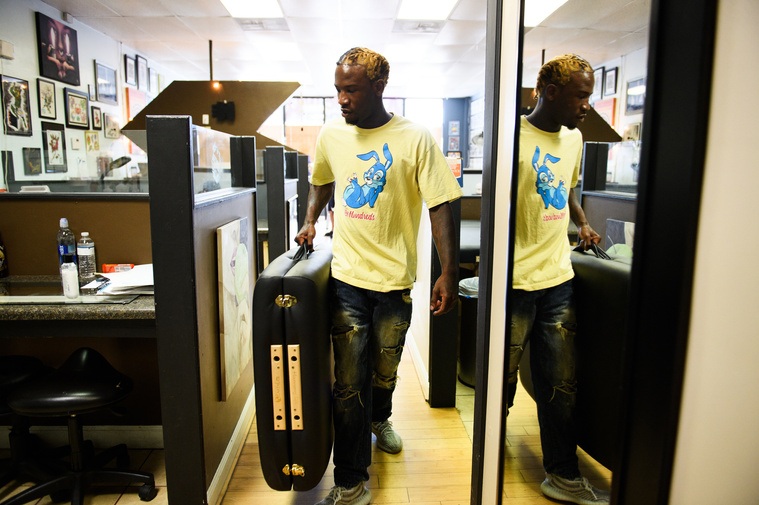 Isaih Kinlock brings a portable bed to his workspace at Artistic Ink tattoo shop in Summerville on Saturday, July 28, 2018.