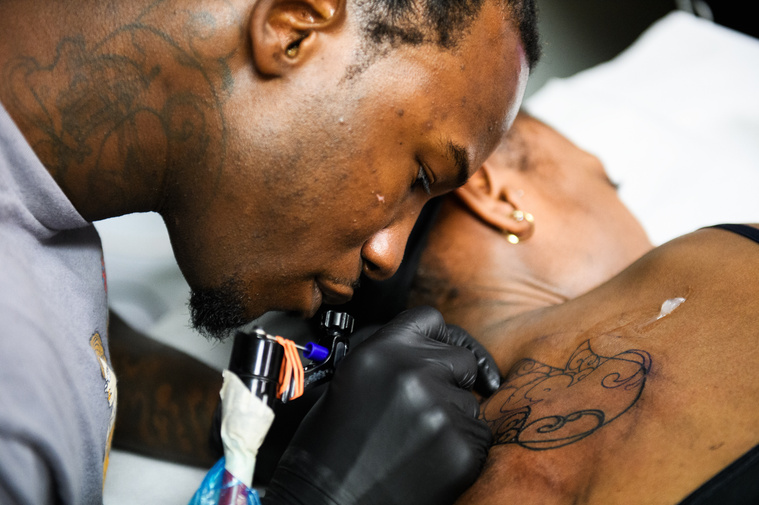 Isiah Kinloch tattoos a client at Artistic Ink in Summerville on Friday, July 27, 2018.
