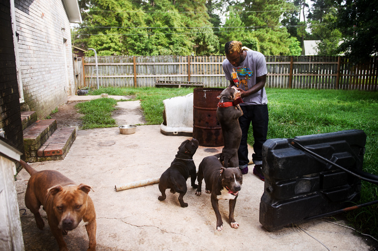 Isiah Kinloch plays with his dogs in his backyard on Thursday, July 27, 2018.
