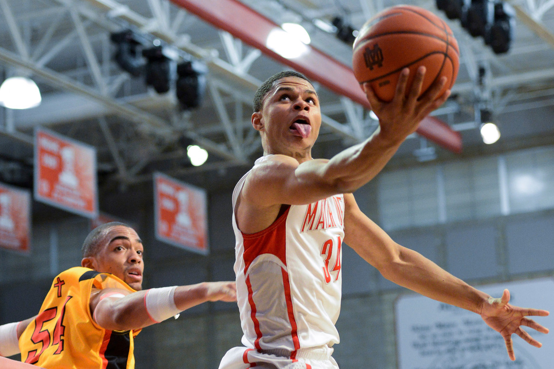 Mater Dei's Jordan Strawberry, left, leaps past Orange Lutheran's Kendall Lauderdale, right, for a layup during a game at Mater Dei High School on Tuesday, Feb 5, 2013.