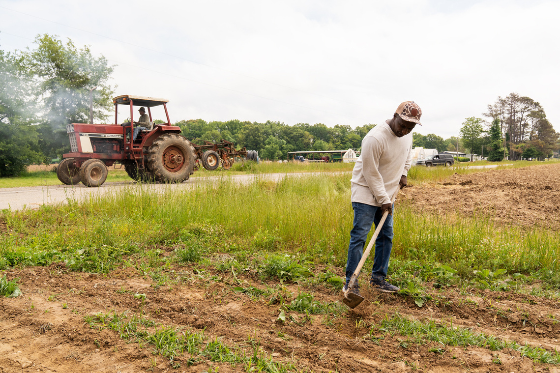 Calvin Head of the Mileston Farming Cooperative tills one of the co-op’s fields as LC Mitchell drives by on his tractor. 