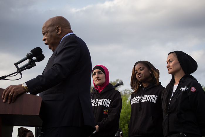March leaders Linda Sarsour, Tamika Mallory, and Carmen Perez stand as civil rights hero Rep. John Lewis praises their march.