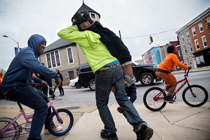Local kids fool around as they follow the marchers through west Baltimore.