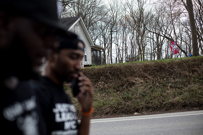 Marchers pass by a house displaying a modified Confederate flag in Cecil County, Maryland. The march passed within a few miles of Rising Sun, a town known as the Maryland headquarters of the Ku Klux Klan. Several passing drivers greeted the marchers with