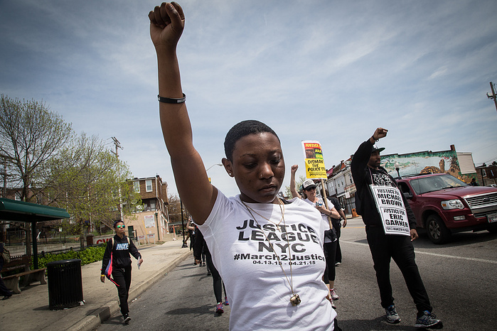 Naima Moore-Turner raises her fist as the marchers head to the BPD Western District to protest the death of Freddie Gray. Naima had tearfully admitted a few days earlier that she did not want to bring children into a world where they would have to fear be