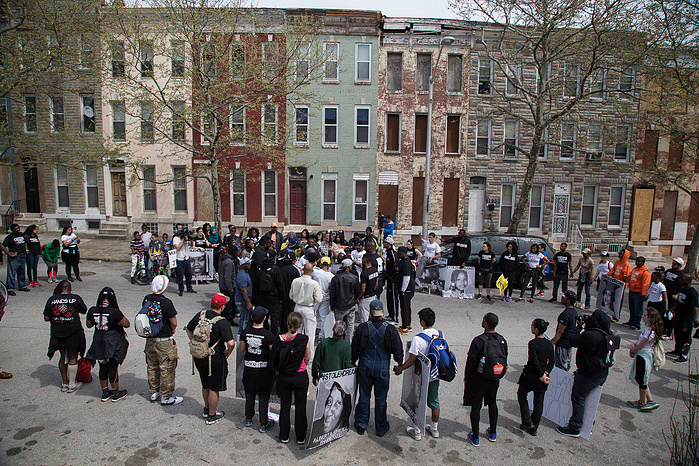 Marchers and locals assemble outside the BPD Western District in response to the death of Freddie Gray.