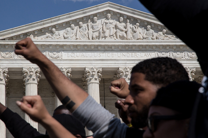 Marchers pass by the Supreme Court on their way to their final rally at the Capitol building.
