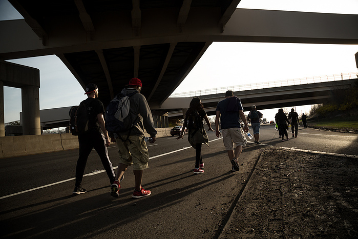 Marchers pass under a freeway interchange in central New Jersey.